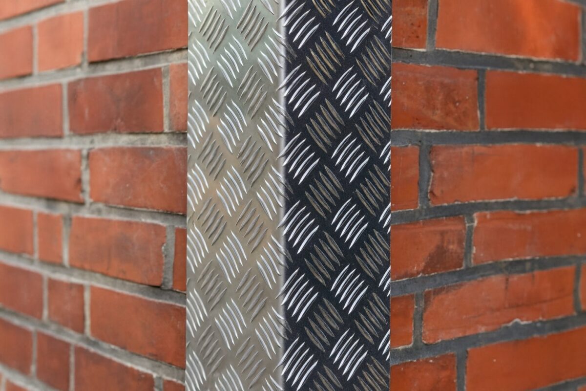 Aluminium-Riffelblech mit markanter Struktur setzt einen robusten Akzent an der Backsteinwand.