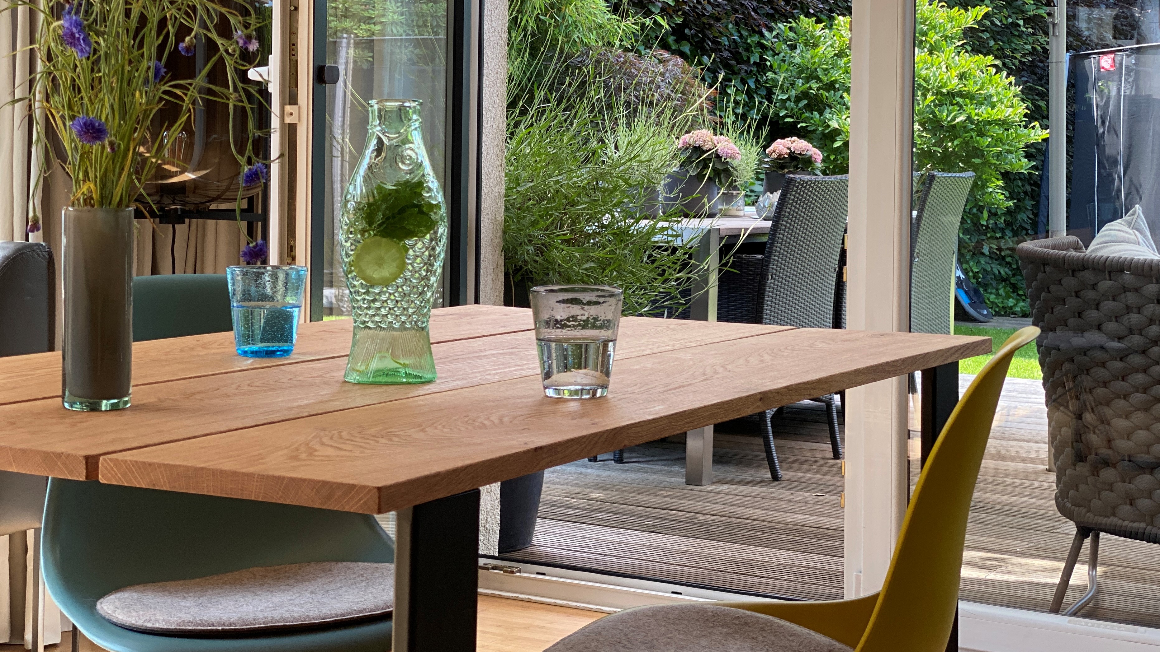 Massivholztisch aus Eiche mit Blick auf Terrasse und Garten.