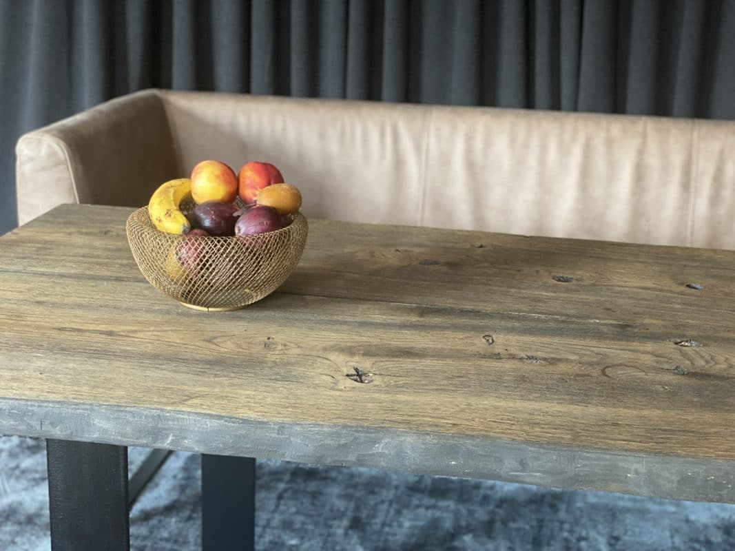 Massiver Eichenholztisch mit Obstschale in modernem Wohnbereich.