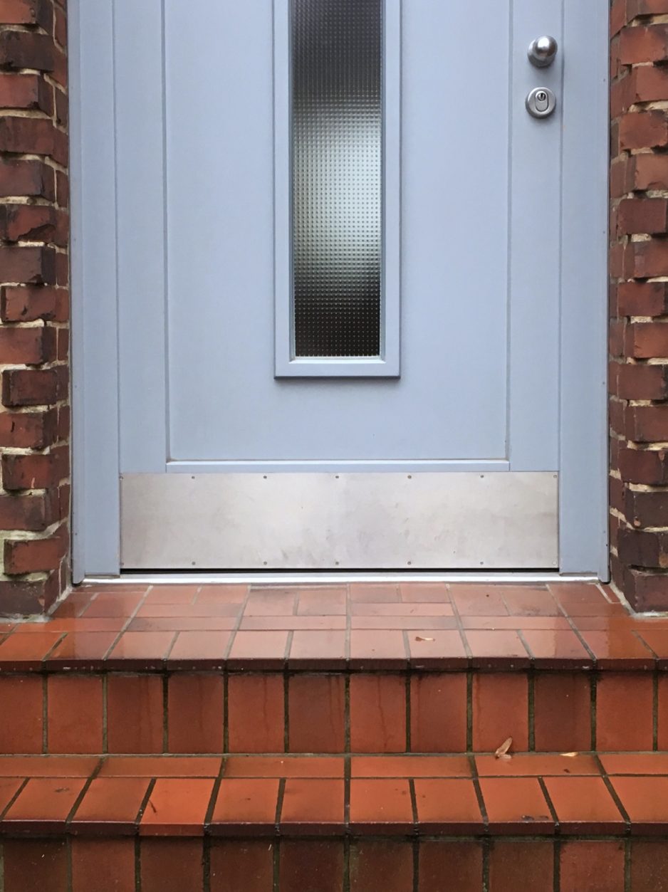 Haustür mit Edelstahl-Trittschutzplatte im unteren Bereich.