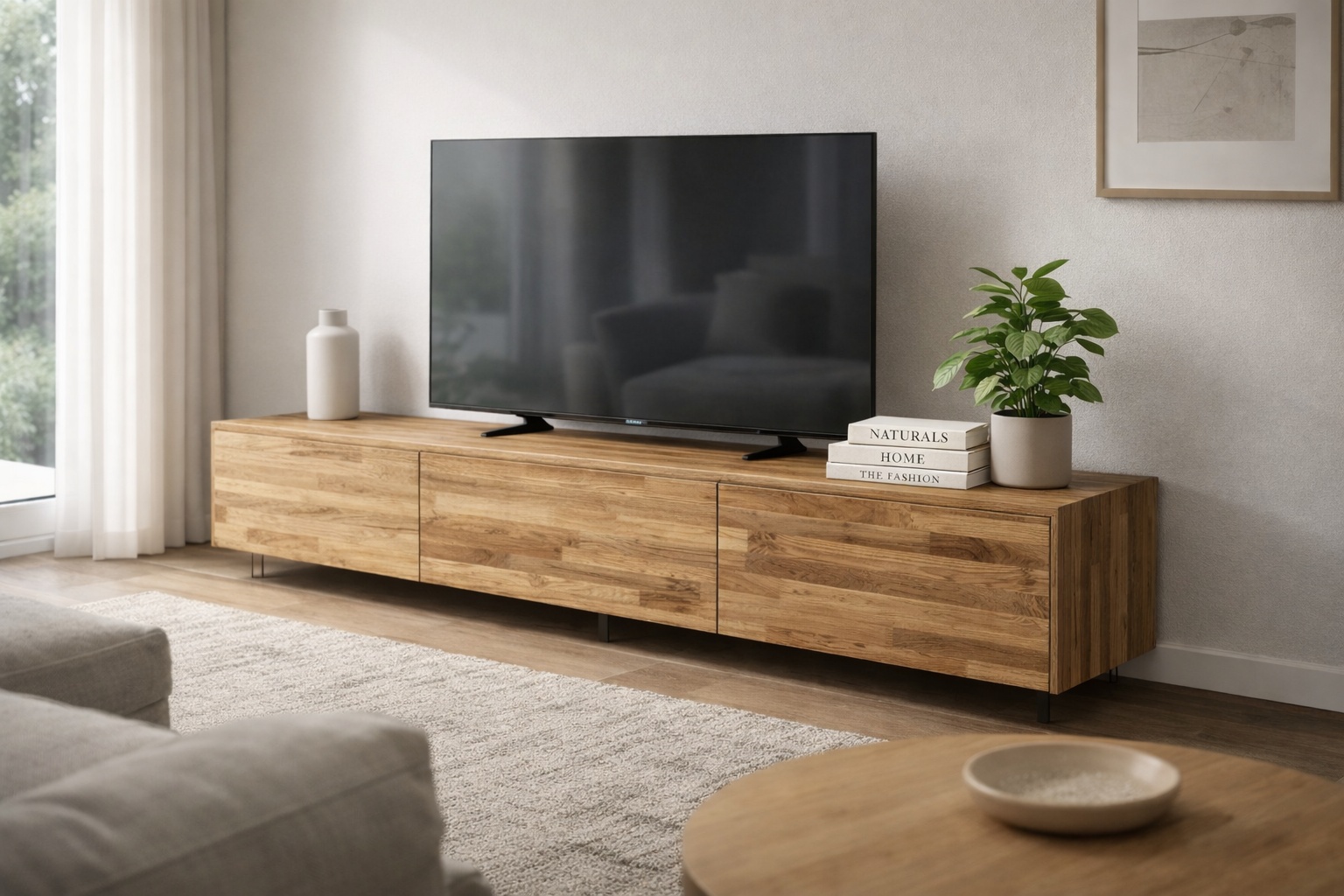 Ein Lowboard aus Eiche Vario-Lamelle steht im Wohnzimmer unter einem Fernseher.