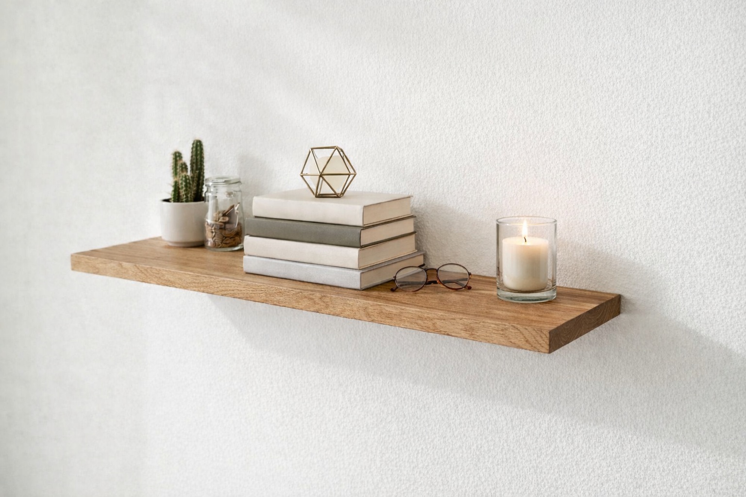 Eine Holzkonsole hängt an der Wand und trägt Bücher und kleine Gegenstände.