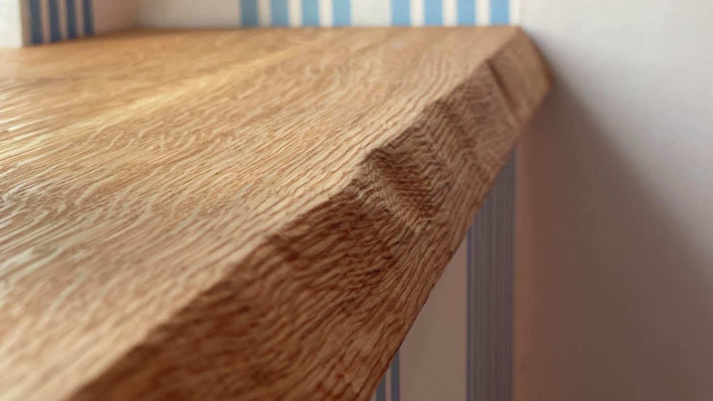 Detailaufnahme einer strukturierten Holzfensterbank mit Naturkante.