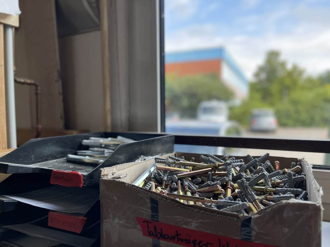 Schrauben mit Dübeln in einem Karton.