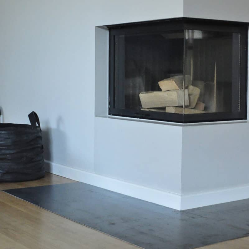 Moderner Kaminofen mit Holzscheiten und Glasfront.