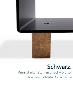 Ein schwarzer Kaminholzständer ruht auf einem massiven Holzblock.