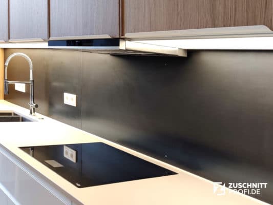 Gezunderter Schwarzstahl verleiht einer Küchenrückwand eine ruhige, matte Industrieoptik.