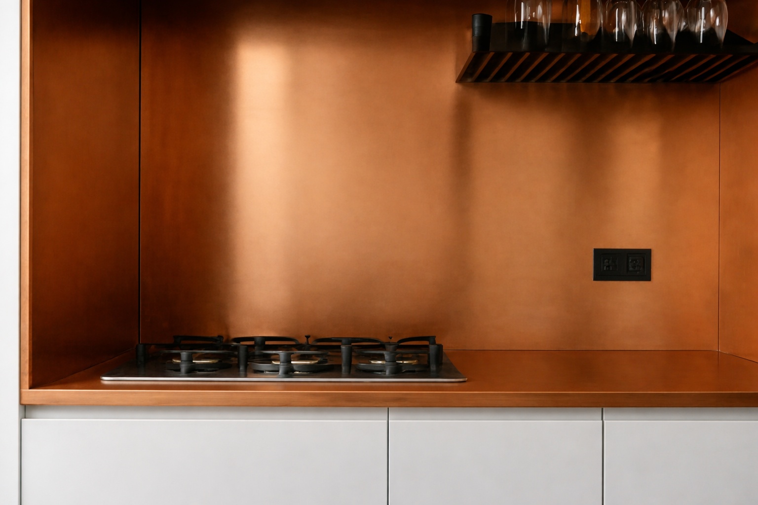 Eine Küche zeigt eine Rückwand aus Kupferblech hinter einem Kochfeld.