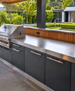 Luxuriöse Outdoor Küche mit Edelstahl Arbeitsplatte, Grill und anthrazitfarbenen Fronten im Garten.
