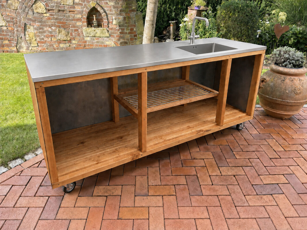 Mobile Outdoorküche mit Edelstahl-Arbeitsplatte, Spülbecken und Wasserhahn auf einer Gartenterrasse im Außenbereich.