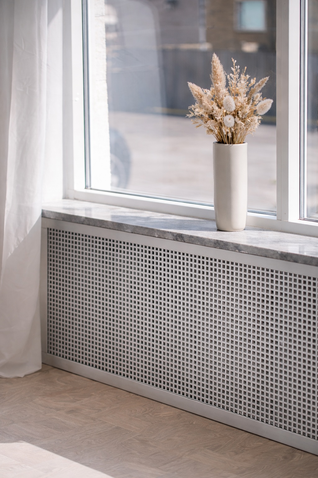 Eine Heizkörperverkleidung aus Lochblech mit Quadratlochung wirkt modern und dezent.