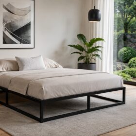 Schwarzes Quadratrohr-Bettgestell im hellen Schlafzimmer mit Teppich, Pflanzen und großer Glasfront.