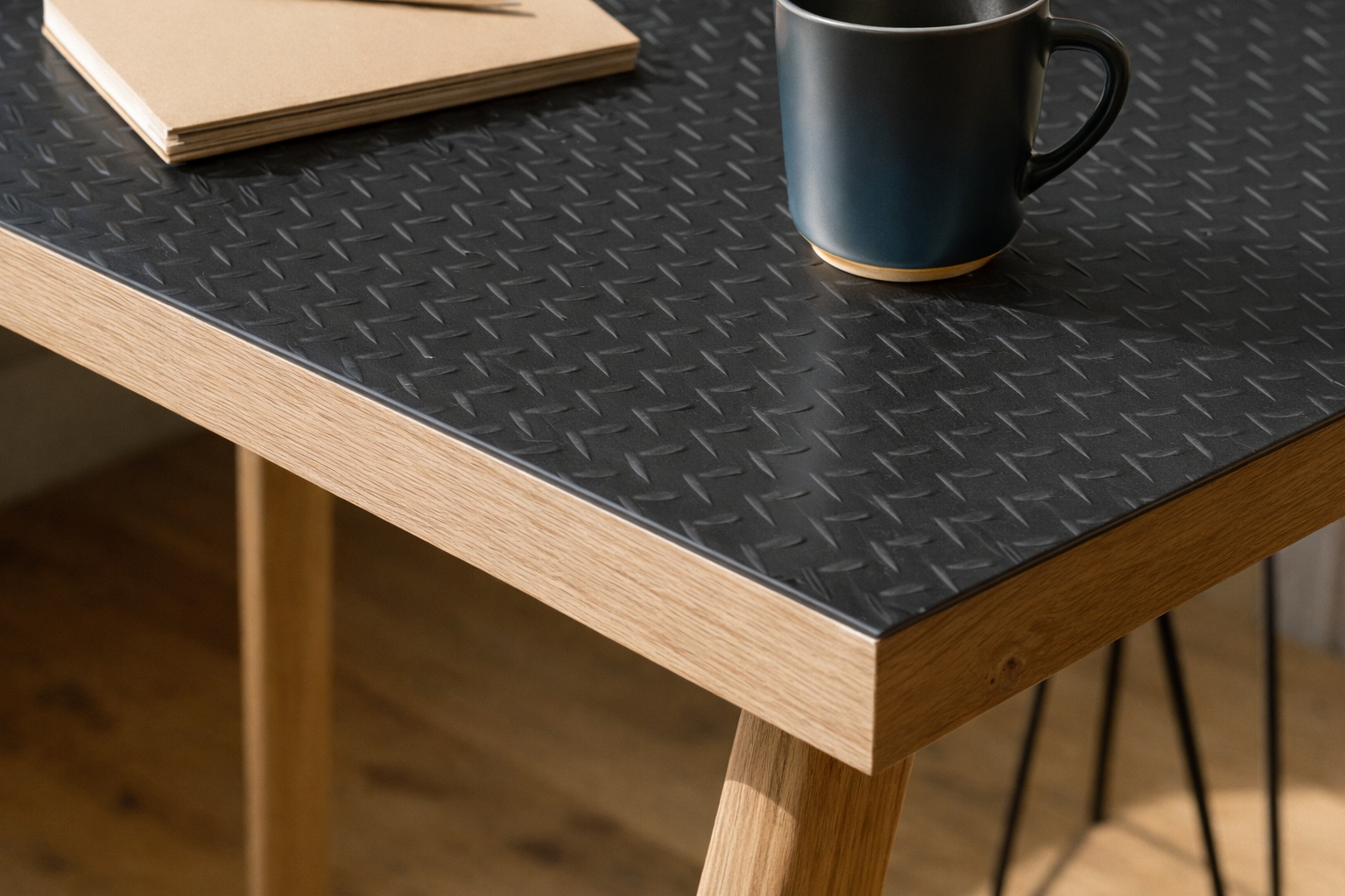 Stahl-Riffelblech dient als robuste Tischoberfläche und setzt einen markanten industriellen Akzent im Zusammenspiel mit Holz.