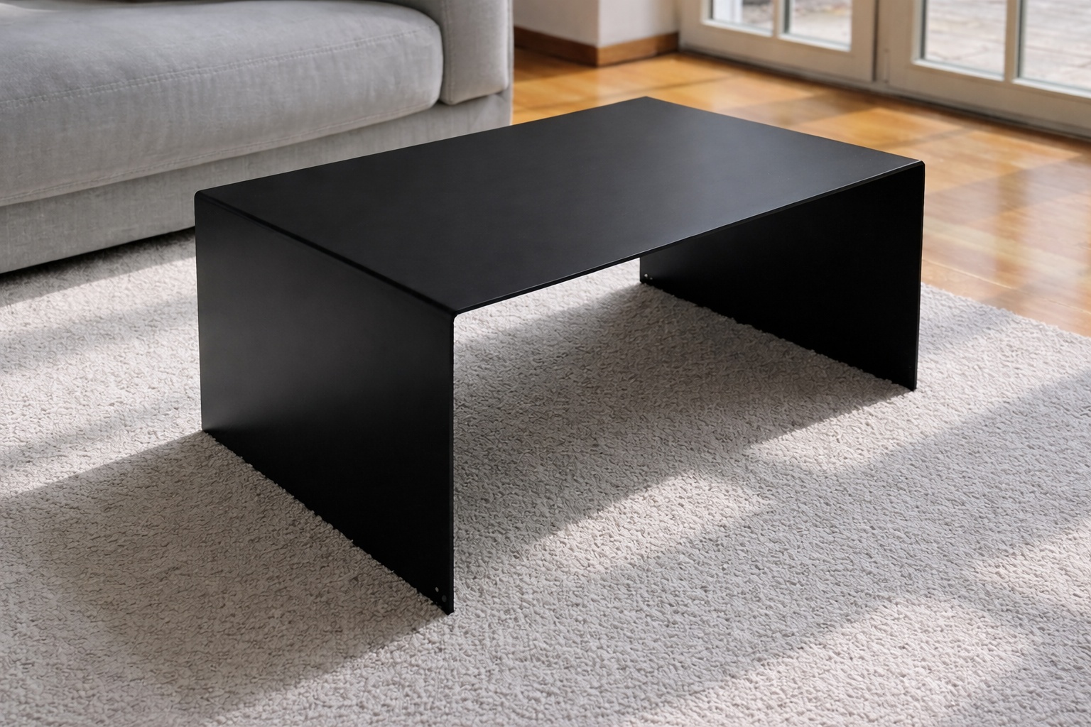 Gezunderter Schwarzstahl formt einen minimalistischen Couchtisch mit klarer Linie und markanter Oberfläche.