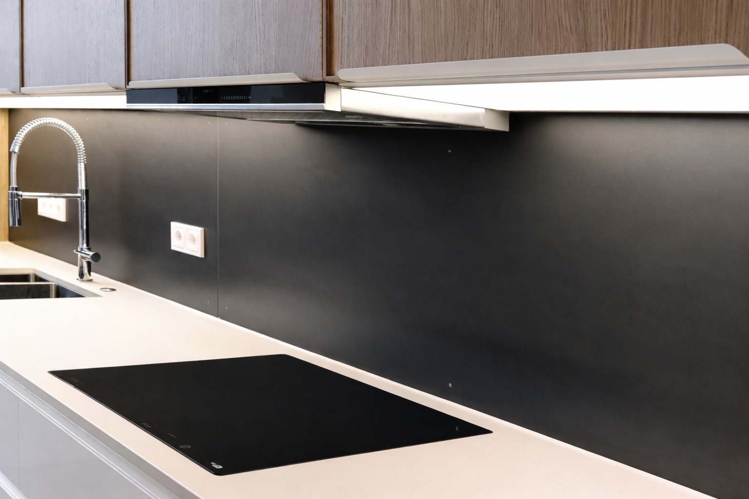 Gezunderter Schwarzstahl verleiht einer Küchenrückwand eine ruhige, matte Industrieoptik.