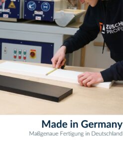 Mitarbeiter misst eine weiße Smart+ Dekorplatte mit einem Maßband in der Werkstatt aus.