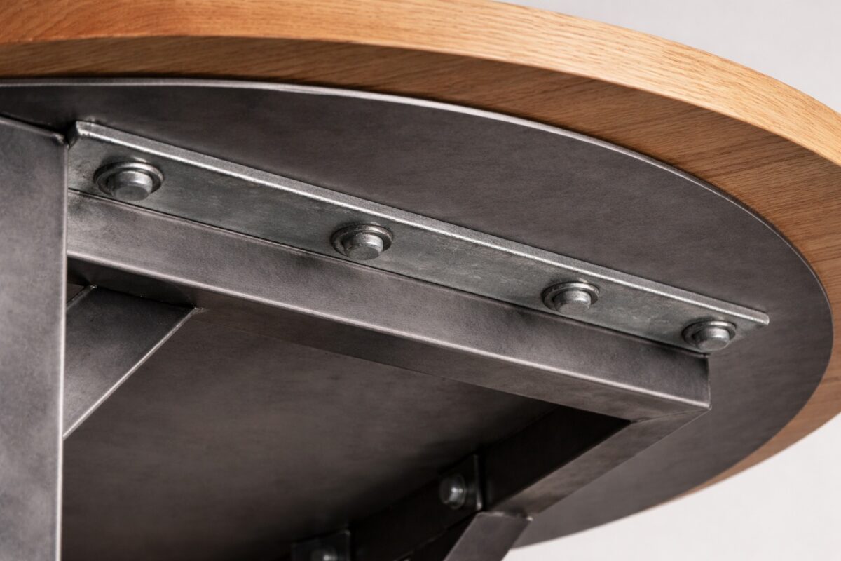 Die runde Stahlunterseite ist unter einer Holzplatte klar sichtbar montiert.