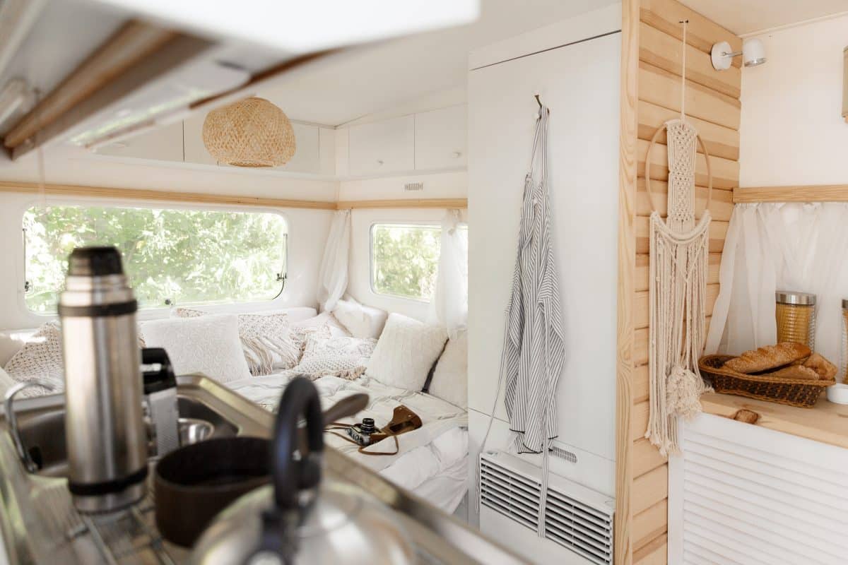 Helles, gemütliches Camper-Interieur mit Küche, Sitzecke und Holzdetails.