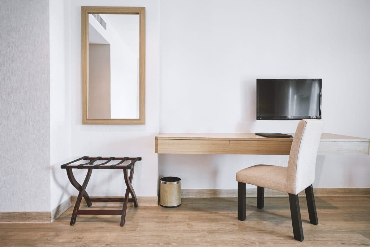 Modernes Hotelzimmer mit einem hängenden Spiegel an der Wand.