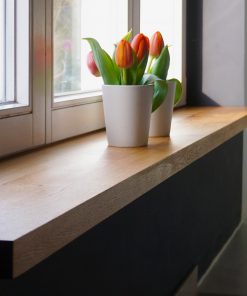 Stilvoll renovierte Fensterbank mit maßgefertigter Abdeckung, modern gestaltet und hochwertig verarbeitet.