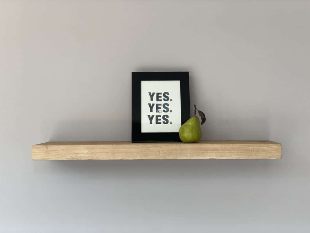 Holzregal mit gerahmtem „YES. YES. YES.“-Print und Birne.