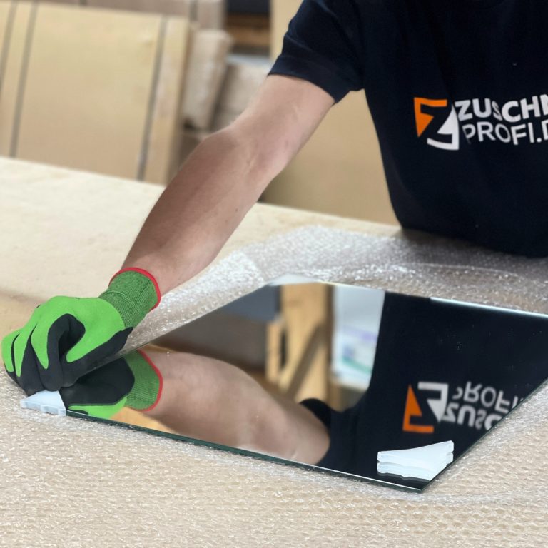 Ein maßgefertigter Kristallspiegel wird in der Fertigung sorgfältig verpackt.