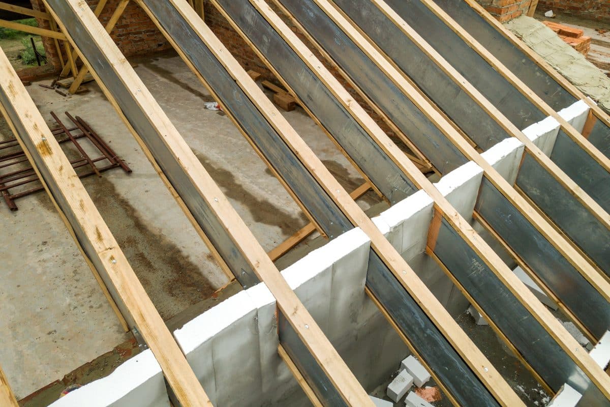 Stahlträger im Dachstuhlbau kombiniert mit Holzbalken auf Mauerwerk.