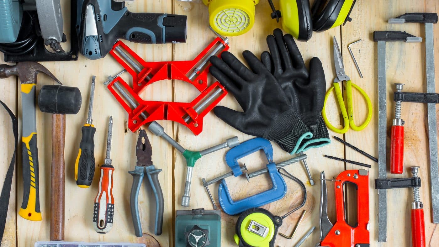 Verschiedenes Werkzeug für Heimwerker auf Holzuntergrund ausgebreitet.